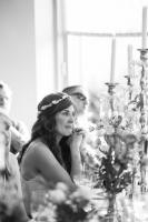 a bride wearing a floral tiara listening to a wedding speech 