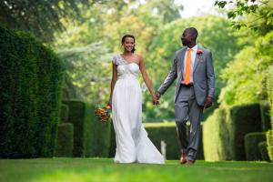 a bride and groom walking through an english country garden after their wedding