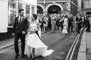 bride and groom walking down the street outside rye town hall and the george in rye